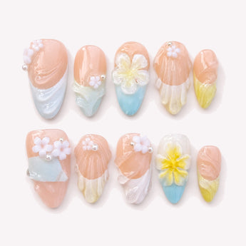 Jardin Pastel short 3D flower nails with a nude-pink base, pastel blue and yellow details, and raised white and yellow flowers.