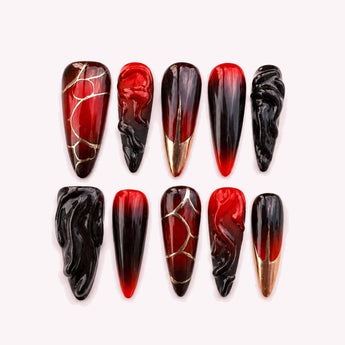 Obsidian Vein red and black ombre press on nails with long stiletto tips, sculptural black 3D ridges and gold-tone crack-like details.