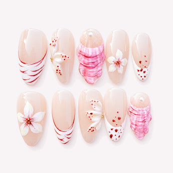 Seashell Garden 3D shell nails with a nude-pink base, sculptural pink shell relief, white floral and French-tip details, red accents, gold-tone details and a medium almond shape.
