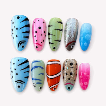 Tropical Clownfish cute tropical nails with aqua blue tones, fish stripes, bubble dots and a short almond shape.