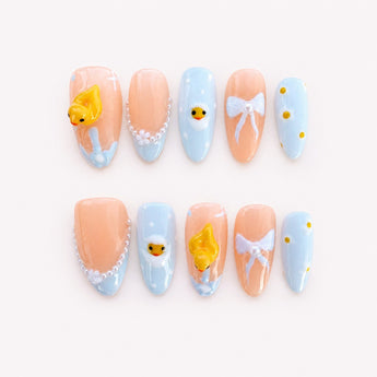 Duckling Bubble Dream cute duck nails with raised yellow ducklings, white bows and baby-blue tips.
