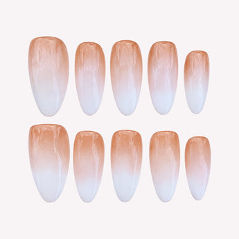 Glossy medium almond nails with an apricot-nude base fading into milky-white tips and no added embellishments.