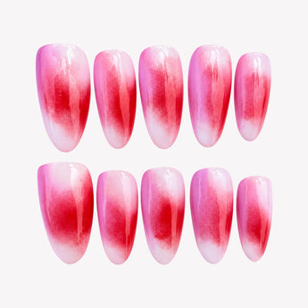 Rosy Haze press-on nails with berry-red patches, soft pink gradients, pale edges and a glossy short almond shape.