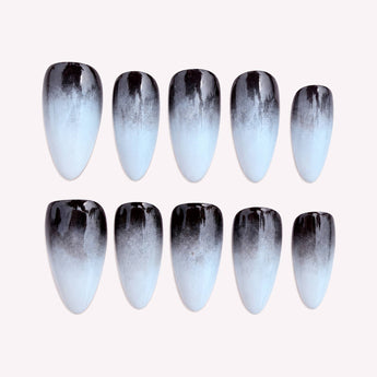 Smoke Veil black ombre nails with a glossy black-to-white fade, shown in a short almond shape with tapered ends.
