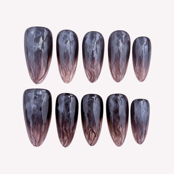 Black jelly press-on nails with smoky brown wisps, a glossy fade, and softly pointed almond tips.