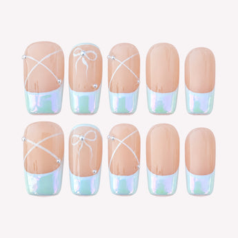 Grace Notes French tip nails with bows, a nude base, and pearlescent tips.