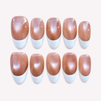 First Blush press-on nails with a warm nude cat-eye shimmer, curved white French tips, and a short almond shape.