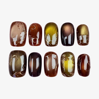 Amber Glow brown cat eye nails with gold-tone scrollwork and velvet-like shimmer.