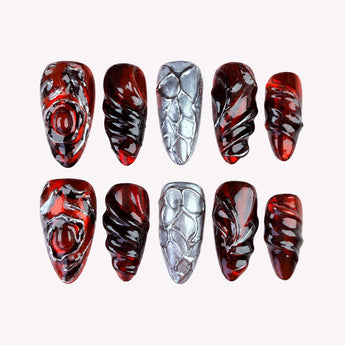 Scarlet Relic press on nails with glossy crimson bases, silver-tone frames and raised gunmetal-looking wraps.