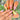 Summer Fruit Medley cute summer almond nails worn on a hand with playful fruit motifs.