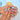 Color Carousel nails in blue, yellow, hot pink and orange, with soft aura-like gradients and an almond shape.