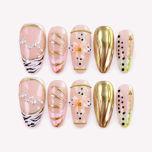 Wild Muse press-on nails with gold-tone chrome-like accents, raised flowers, zebra tips, and pearl-like details